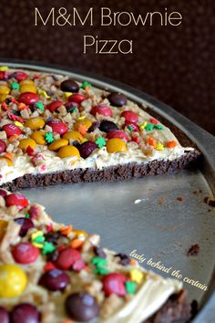 a cake that has been decorated with candy and m & m brownie pizza slices