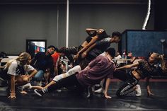 a group of people in a dance studio doing different moves on the floor with their hands together