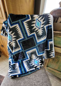 a black and blue blanket sitting on top of a chair