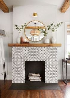 a fireplace with a mirror above it and some plants on the mantle in front of it