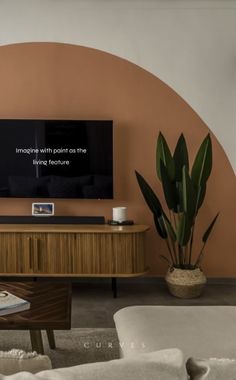 a flat screen tv sitting on top of a wooden entertainment center next to a potted plant