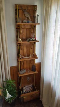 a tall wooden shelf sitting in the corner of a living room next to a window