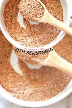 two white bowls filled with fish seasoning and wooden spoons