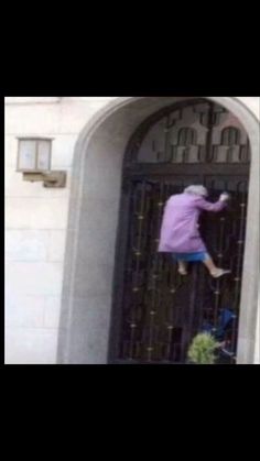 a person climbing up the side of a building with their feet in an open door