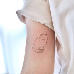 a small tattoo on the arm of a woman's left arm, with a drawing of a hippo