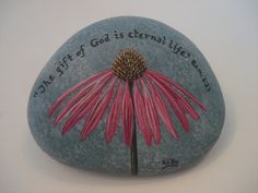 a painted rock with a pink flower on it that says, the gift of god is external life meaning