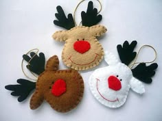 three felt reindeer ornament ornaments hanging on a white surface with red nose and black antlers