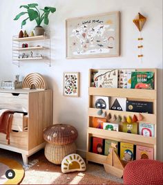 a child's room with bookshelves, toys and pictures on the wall