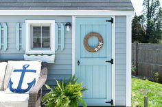 a blue and white house with an anchor wreath on the door