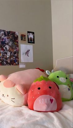 there are many stuffed animals laying on the bed with each other's head and pillows