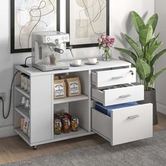 a white coffee machine sitting on top of a counter next to a potted plant