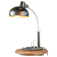 an industrial desk lamp on top of a wooden base with a metal shade over it