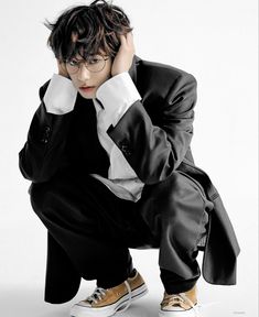 a man in a suit and tie sitting on the ground with his hands behind his head