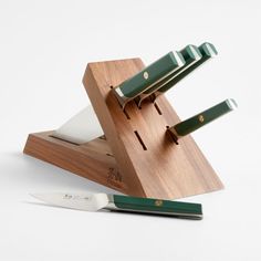 a knife holder with three knives on it and a cutting board attached to the top