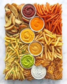 a platter filled with fries, dips and sauces on top of each other