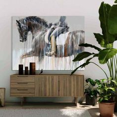 a painting on the wall next to a dresser and potted plant in front of it