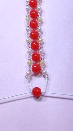 a red and white beaded necklace on a string