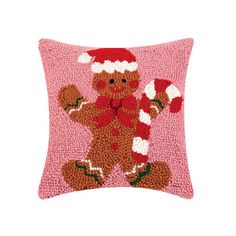 a pink pillow with a teddy bear wearing a santa hat and mittens on it