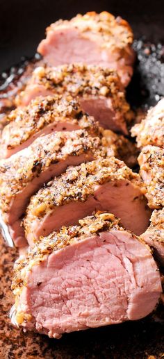 some meat is being cooked in a skillet on the stove with seasoning sprinkles