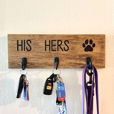 a wooden sign that says, his hers with keys hanging from hooks and lanyards