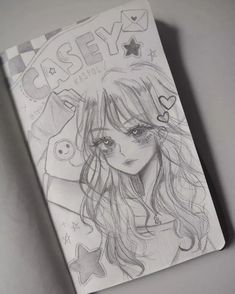 a drawing of a girl with long hair and stars on her head, next to a notebook