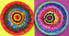 two paper plates with designs on them sitting next to each other in front of a colorful wall