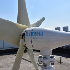 a white wind turbine sitting on top of a roof