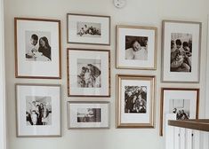 a bunch of pictures hanging on the wall above a table with a potted plant