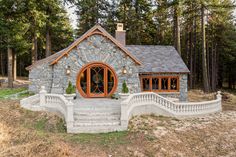 a small stone house in the woods with steps leading up to it's entrance