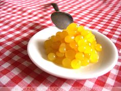 a white bowl filled with jelly beans on top of a red and white checkered table cloth