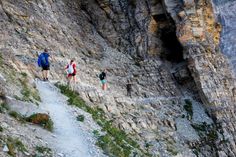 three people hiking up the side of a mountain