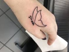 a person's hand with a small tattoo on the left side of their finger