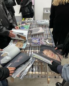 people are looking at magazines on a table