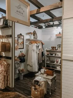 the inside of a clothing store with clothes hanging on racks and other items in baskets