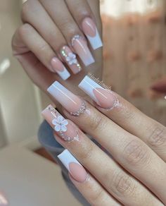 a woman's hands with french manies and flowers on the tip of their nails