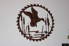 a metal wall hanging with an eagle and reeds in the center on a white wall