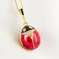 "Enameled and 24 K gold plated over solid sterling silver, ladybug egg pendant created in the famous tradition of Faberge jewelry in our NJ shop.   As kids , we would hold a ladybug in an open palm and sing something like that:  Ladybug, ladybug, fly in to the sky, bring us some bread, any kind, just make sure that it is not burned.    The pendant is about 0.7\" long not including the bail for a chain.  Clear crystals are set in the eyes and in the neck of the bug on both sides of the egg.  Well Yellow Gold Enamel Oval Pendant Jewelry, Yellow Gold Enamel Oval Pendant Necklaces, Black Enamel Oval Necklace As Gift, Black Enamel Oval Necklace For Gift, Oval Black Enamel Jewelry Gift, Enamel Hallmarked Oval Pendant Necklace, Yellow Gold Necklaces With Black Enamel For Gift, Gold Enamel Necklaces With Cabochon, Gold Enamel Necklace With Cabochon