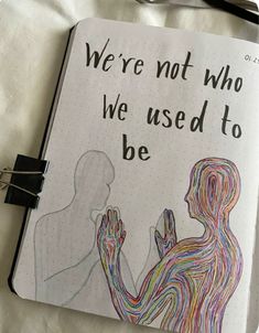 a notebook with a drawing of two people holding hands and the words we're not who we used to be