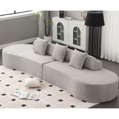 a large gray couch sitting on top of a white rug