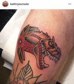 a close up of a person's leg with a tattoo on it and an image of a dragon