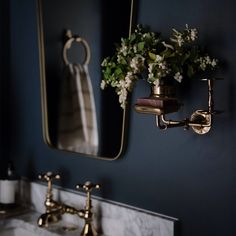 a bathroom sink sitting under a mirror next to a faucet with flowers on it