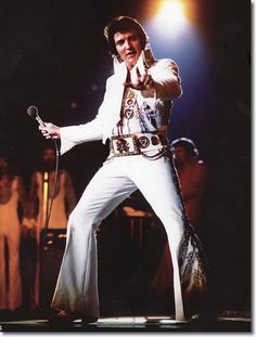 elvis presley performing on stage with microphone in hand