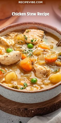 a bowl of chicken stew with carrots and peas