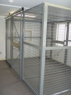 two large metal cages in an empty room