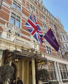 the connaught hotel in london, england with flags flying from it's entrance