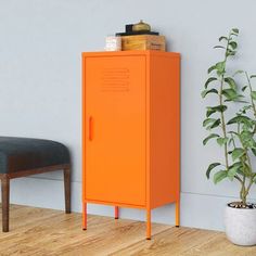 an orange locker next to a plant in a room