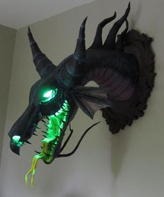 a green dragon head mounted to the side of a wall