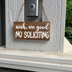 a wooden sign that says no soliciting dogs are napping on the front porch