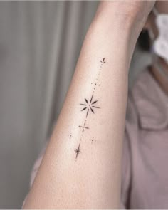 a woman's arm with a star tattoo on it