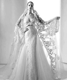 a woman in a wedding dress is posing for the camera with her veil over her head